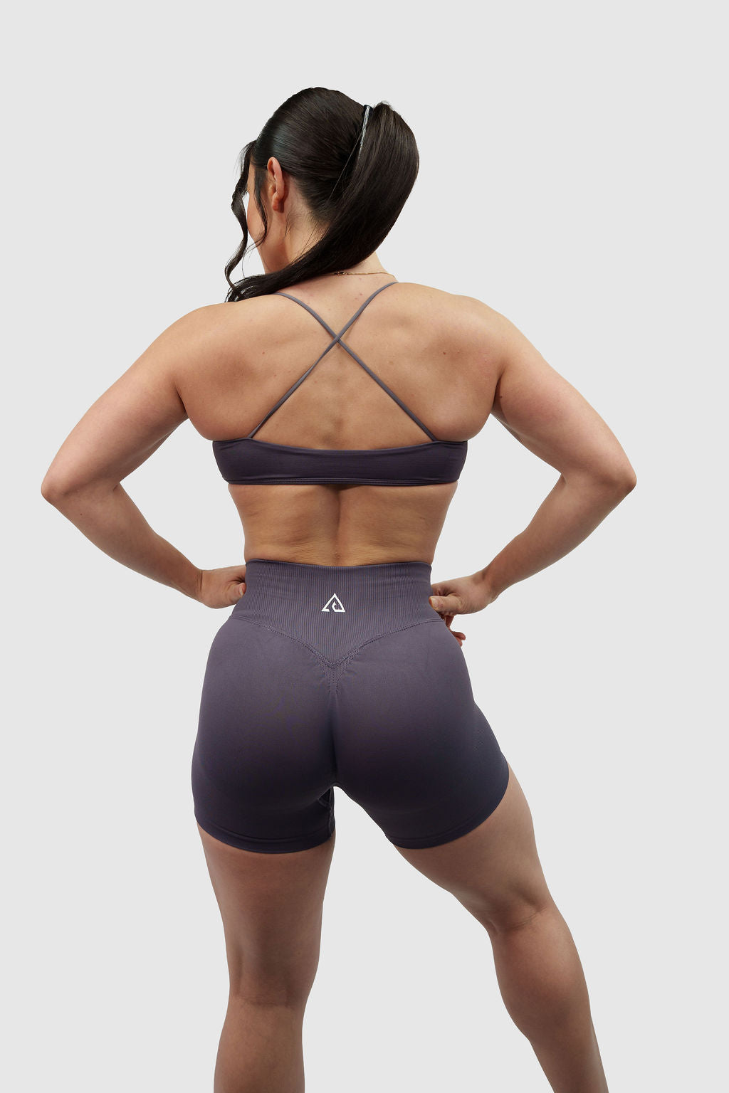 NOXVIA Ash Taupe gym set, back view showing the cross-back sports bra, high-rise sculpt shorts, rear contour shaping and NOXVIA logo
