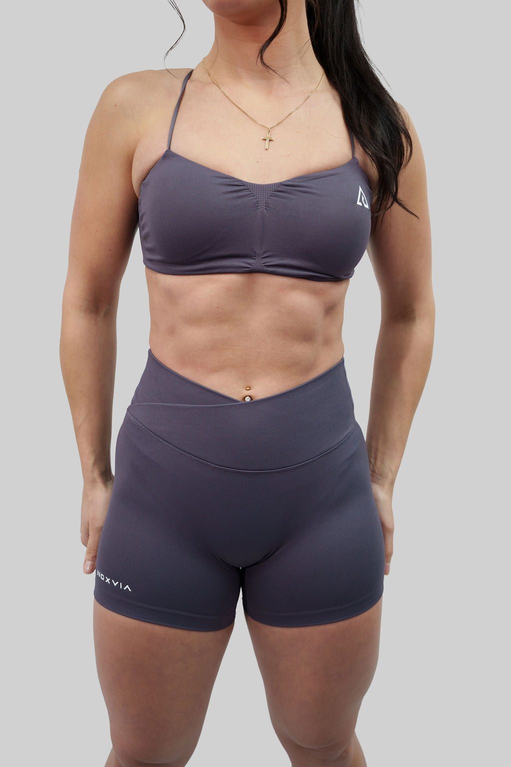 NOXVIA Ash Taupe gym set, front detail showing the ruched sports bra, high-rise crossover sculpt shorts and NOXVIA branding
