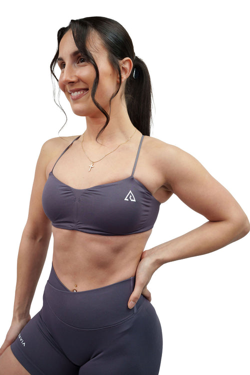 NOXVIA Ash Taupe sports bra, front detail showing the ruched neckline, slim straps and NOXVIA logo
