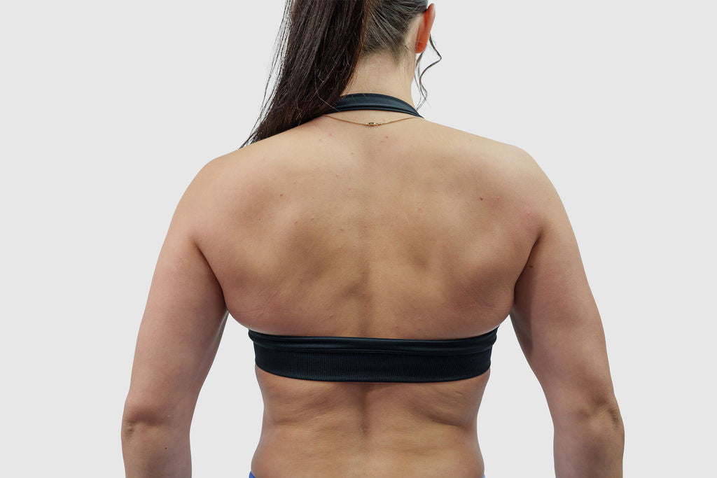 NOXVIA black halter sports bra, back detail showing the halter neck, open-back design and supportive underband
