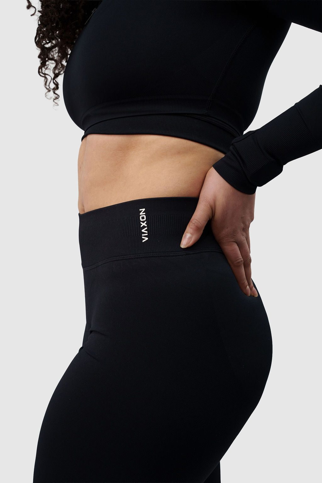 NOXVIA black sculpt leggings, side detail showing the high-rise waistband, sculpted fit and NOXVIA branding
