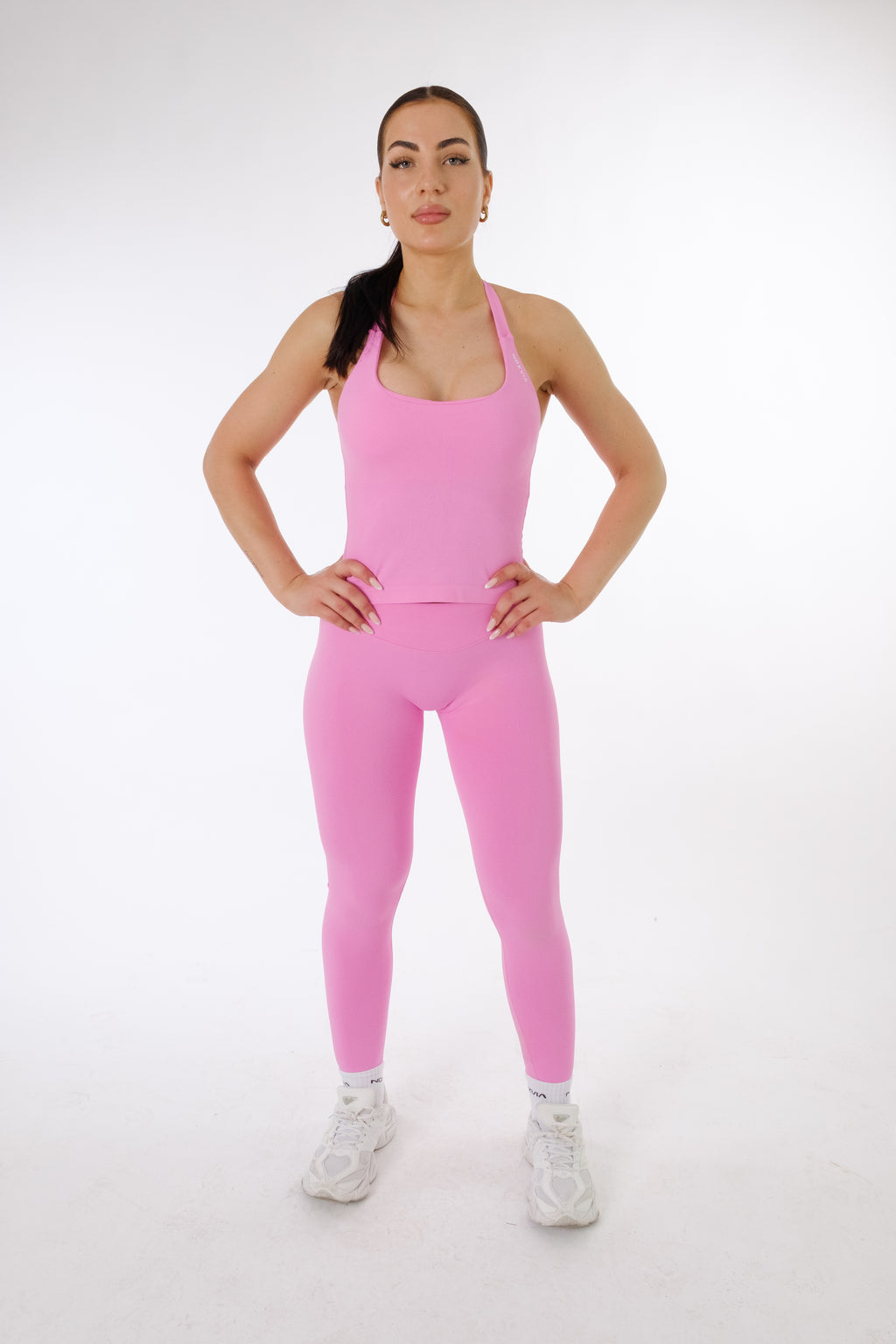 Model wearing the NOXVIA NOVA Candy Pink halter top and matching seamless sculpt leggings.