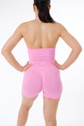 Back view of the NOXVIA NOVA Candy Pink halter top and matching seamless sculpt shorts, showing the open back and high waistband.