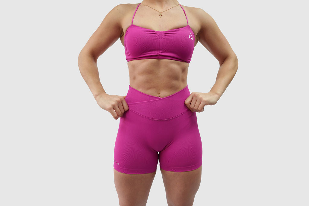 NOXVIA Nova Pink gym set, front detail showing the ruched sports bra, high-rise crossover sculpt shorts and NOXVIA branding

