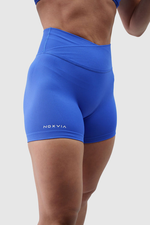 NOXVIA Royal Dominion blue sculpt shorts, front detail showing the high-rise crossover waistband, sculpted fit and NOXVIA branding
